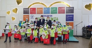 Environment and Urbanization Minister Murat Kurum, Esenler Mayor Tevfik Göksu and Istanbul Governor Ali Yerlikaya pose with children who received recycled notebooks, Istanbul, Turkey, Oct. 8, 2020. (DHA Photo)