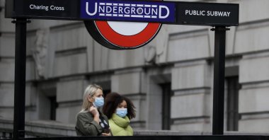 Pedestrians wear masks as they walk near a subway station in London, U.K., June 5, 2020. (AP Photo)