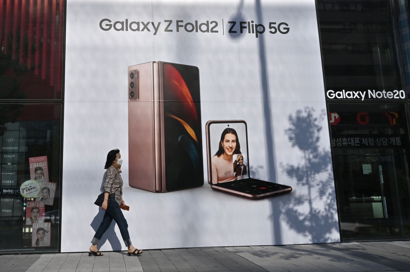 A woman walks past an advertisement for the Samsung Galaxy Z Fold2 and Z Flip smartphones at a Samsung Electronics store in Seoul on Oct. 8, 2020. (AFP Photo)