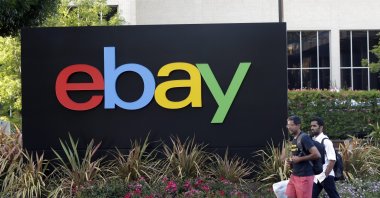 People walk in front of an eBay Inc. sign at the company's headquarters in San Jose, California, U.S., June 5, 2014. (AP Photo)