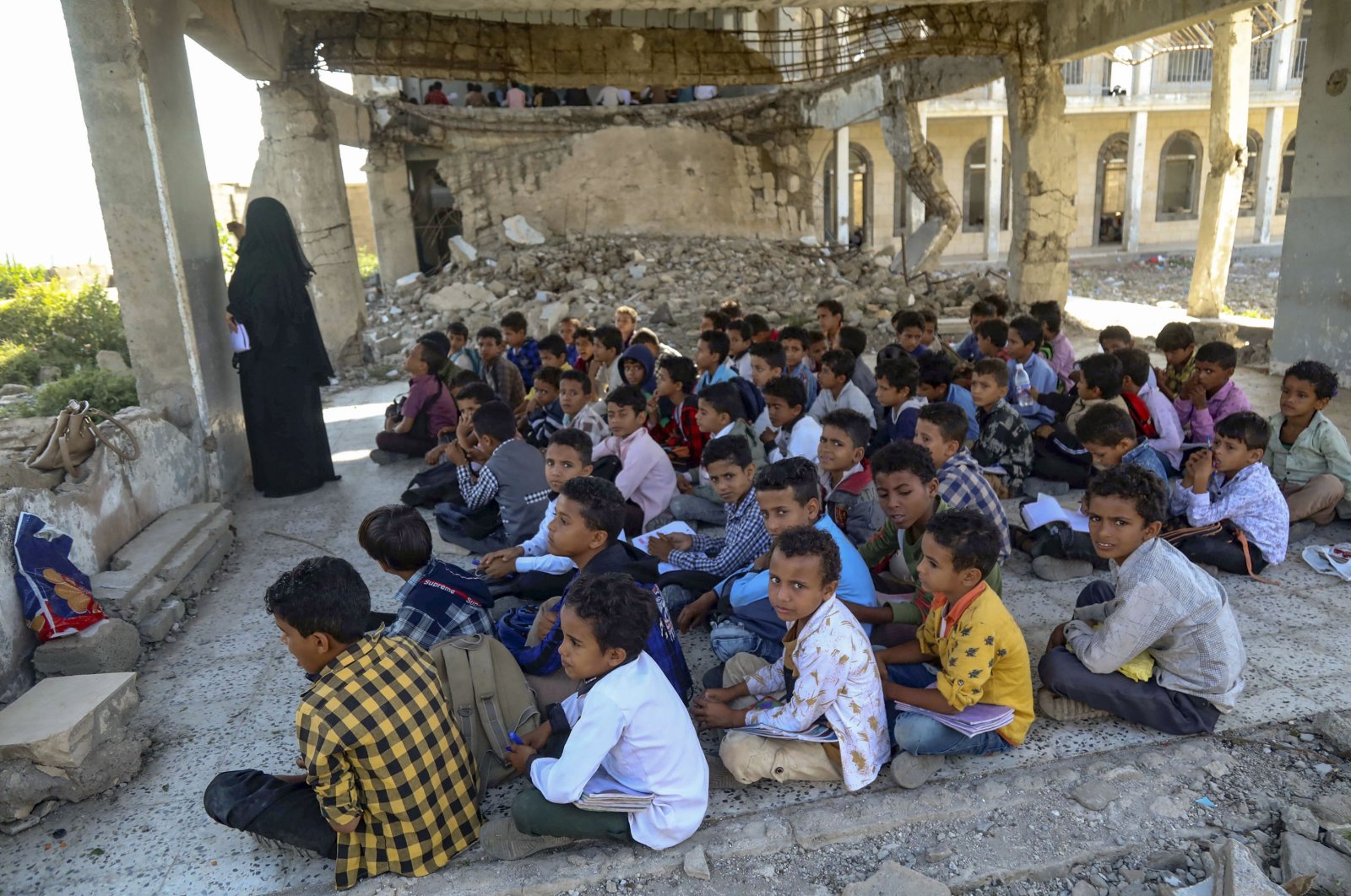 Yemeni pupils attend class on the first day of the new academic year in a makeshift classroom in their school compound, which was heavily damaged two years ago in an air strike, in the country's third-city of Taez on Oct. 7, 2020. (AFP Photo)