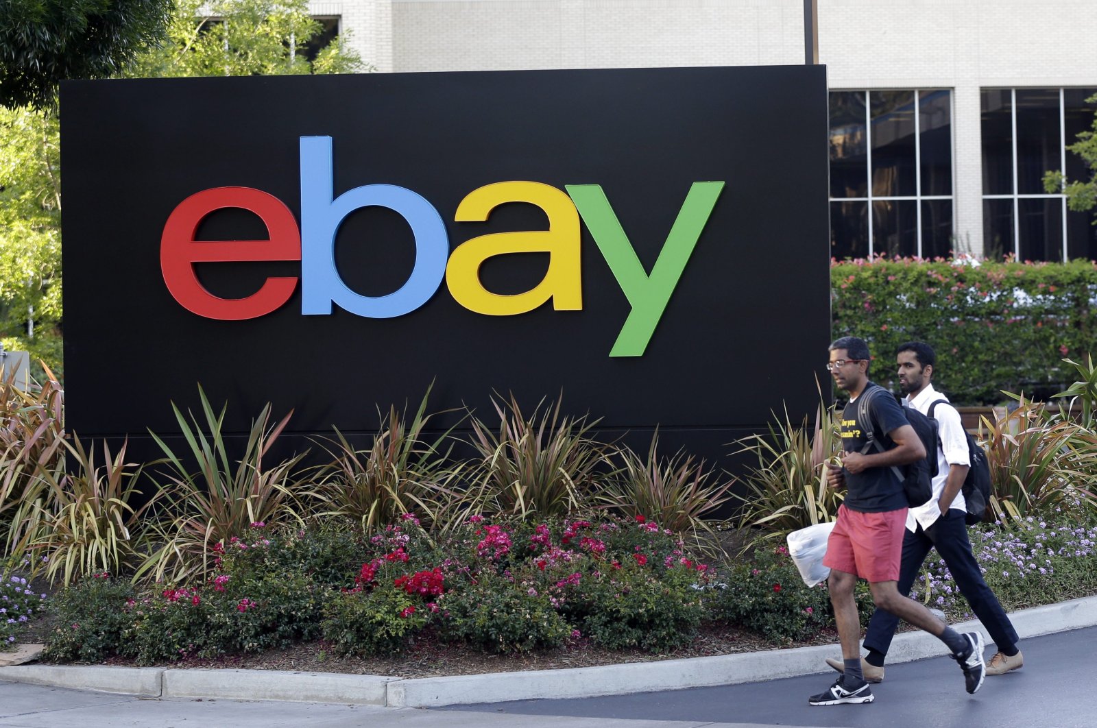 People walk in front of an eBay Inc. sign at the company's headquarters in San Jose, California, U.S., June 5, 2014. (AP Photo)