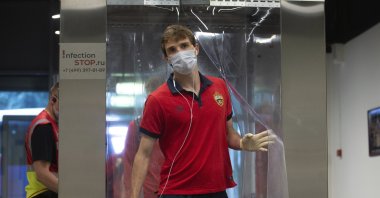 CSKA's Mario Fernandes, wearing face mask and gloves, passes through a disinfection tunnel to protect the spread of coronavirus before the Russia Soccer Premier League soccer match between CSKA Moscow and Zenit St. Petersburg at CSKA Arena in Moscow, Russia, June 20, 2020. (Denis Tyrin, PFC CSKA Pool photo via AP)