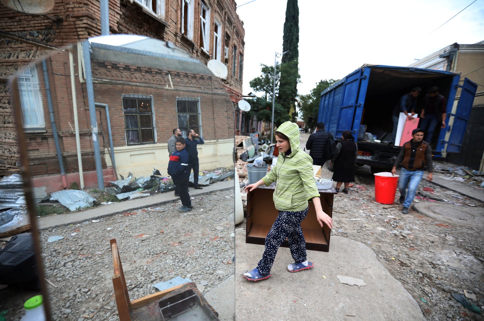 People load belongings into a truck next to a house damaged by Armenian shelling during a military conflict over Armenian-occupied Nagorno-Karabakh, in the city of Ganja, Azerbaijan, Oct. 6, 2020. (Reuters Photo)