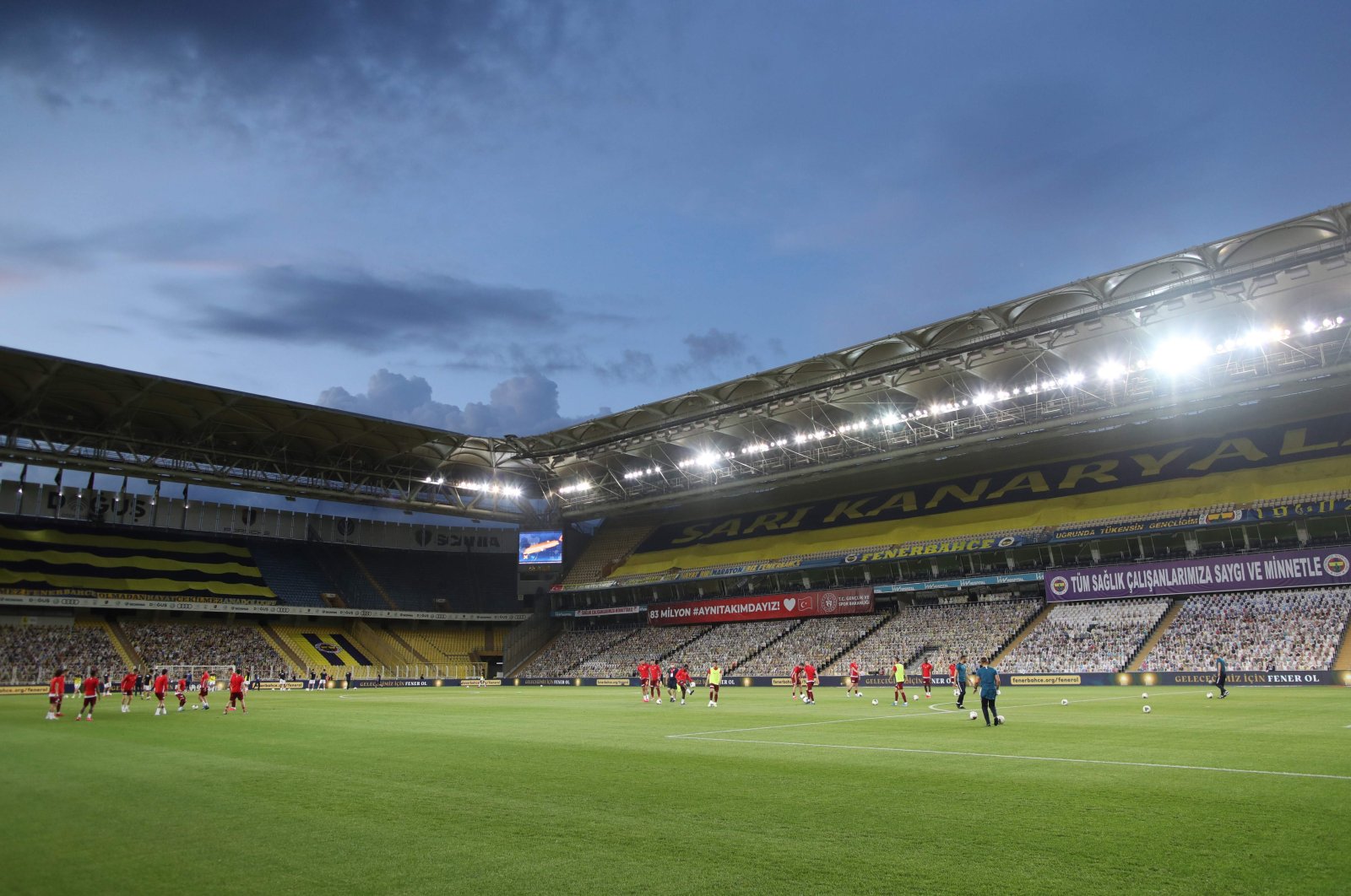 Fenerbahçe and Kayserispor's players warm up in front of cardboards with photographs of Fenerbahçe fans on the stands ahead of the Turkish Super Lig football match between Fenerbahçe and Kayserispor at the Şükrü Saraçoğlu Stadium in Istanbul on June 12, 2020. (AFP Photo)