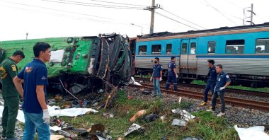 Rescue workers stand at the crash site where a train collided with a passenger bus in Chachoengsao province in central Thailand, Oct. 11, 2020. (Reuters Photo)