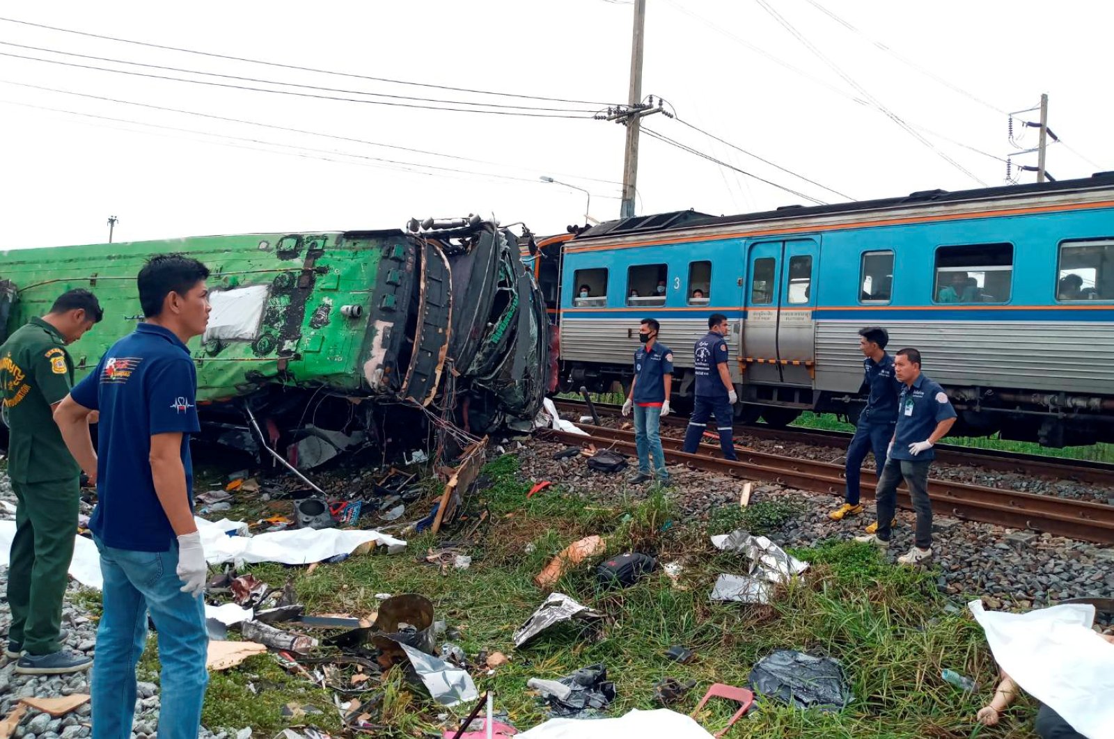 Rescue workers stand at the crash site where a train collided with a passenger bus in Chachoengsao province in central Thailand, Oct. 11, 2020. (Reuters Photo)
