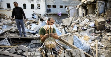 An Azerbaijani man carries a chandelier away from the ruins of a blast site hit by an Armenian rocket over the conflict in the occupied region of Nagorno-Karabakh in the city of Ganja, Azerbaijan, Oct. 11, 2020. (Reuters Photo)