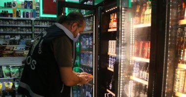 A police officer inspects a liquor store against bootleg alcohol sales in Istanbul, Turkey, Oct. 11, 2020. (DHA Photo) 