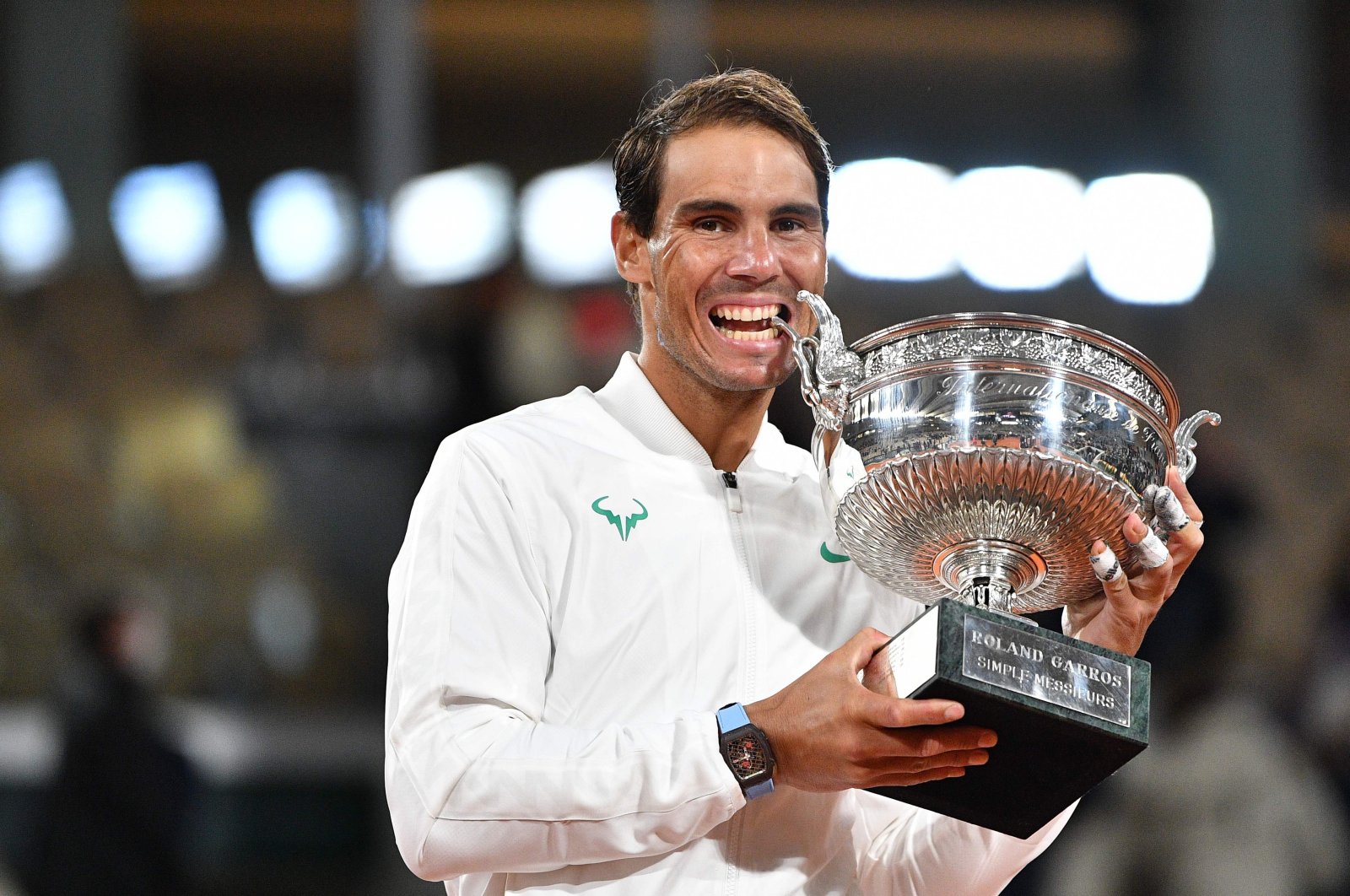 Rafael Nadal bites the French Open trophy as he celebrates winning the men's singles final against Novak Djokovic, in Paris, France, Oct. 11, 2020. (AFP Photo)