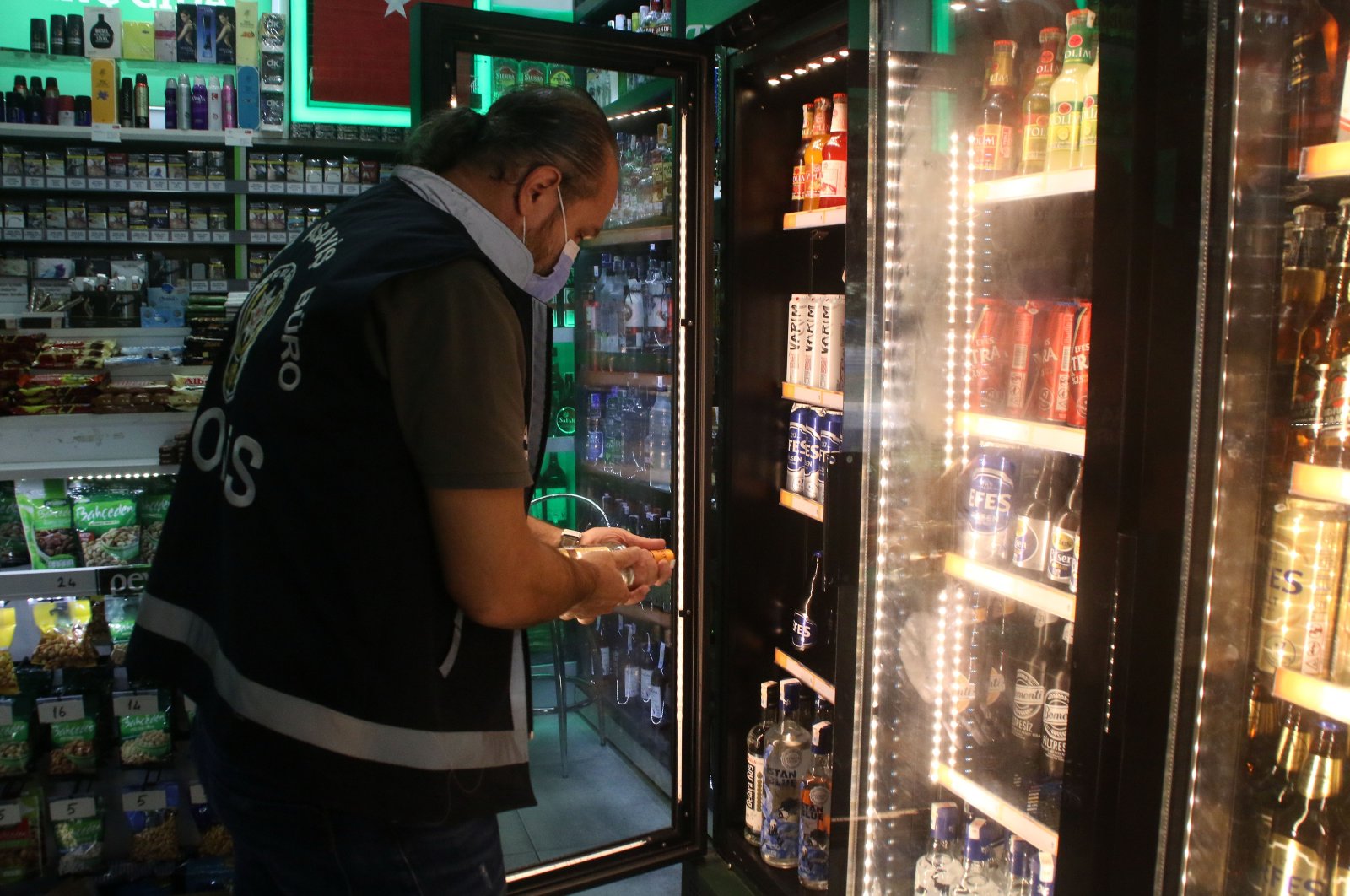 A police officer inspects a liquor store against bootleg alcohol sales in Istanbul, Turkey, Oct. 11, 2020. (DHA Photo) 