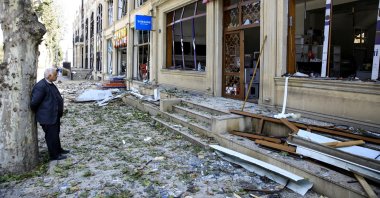 A shop owner stands in front of his store at a blast site from an Armenian rocket in the city of Ganja, Azerbaijan, Oct. 11, 2020. (Reuters Photo)
