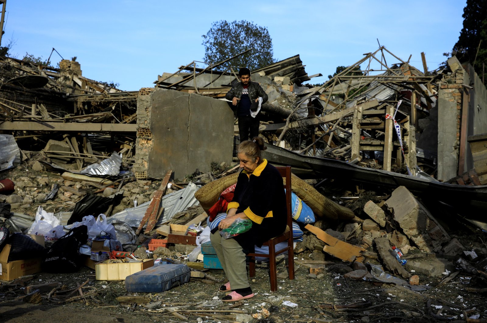 Vesile Mehmedova sits in front of the debris of her brother's home as her relatives search for belongings, at a blast site hit by an Armenian rocket in the city of Ganja, Azerbaijan, Oct. 11, 2020. (Reuters Photo)