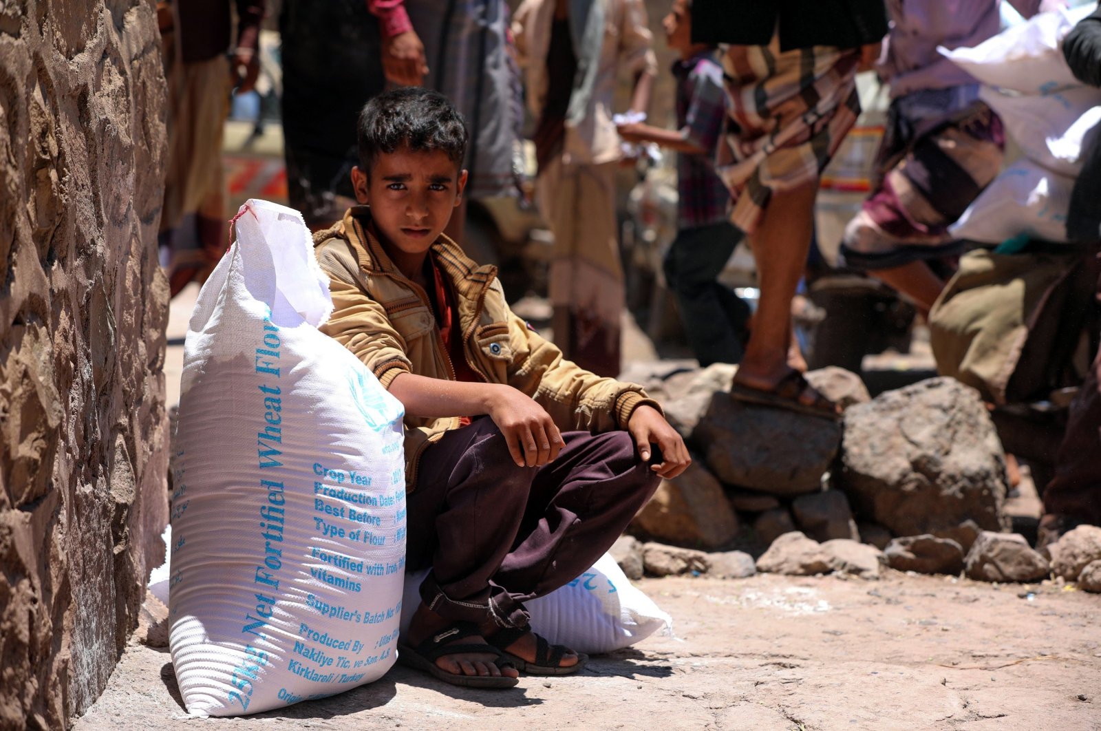 A Yemeni boy receives humanitarian aid donated by the World Food Programme (WFP) in the country's third-largest city of Taiz, Yemen, Oct. 10, 2020. (AFP Photo)