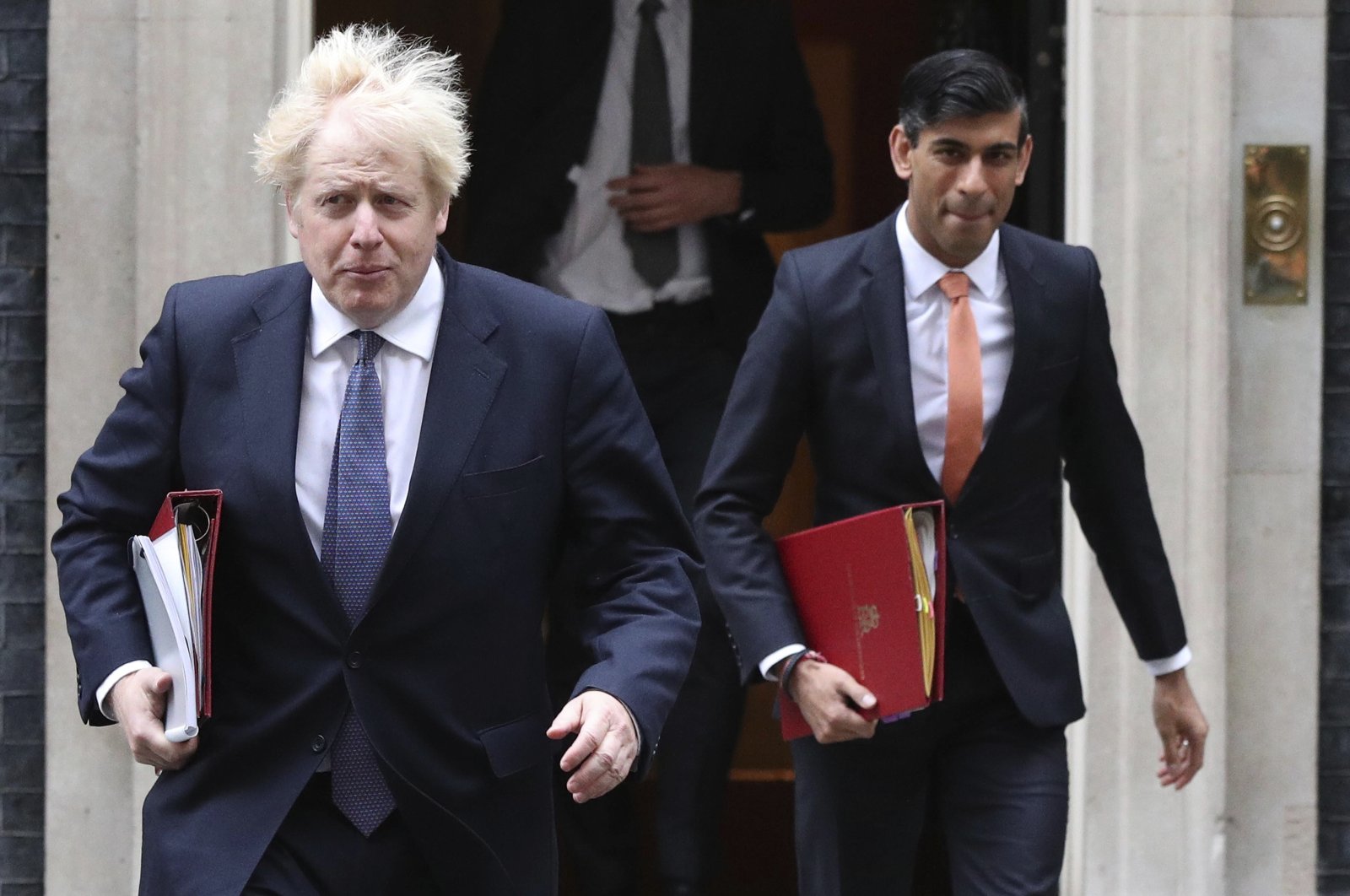 Britain's Prime Minister Boris Johnson (L) and Chancellor of the Exchequer Rishi Sunak leave 10 Downing Street London, ahead of a Cabinet meeting at the Foreign and Commonwealth Office, Oct. 13, 2020. (AP Photo)