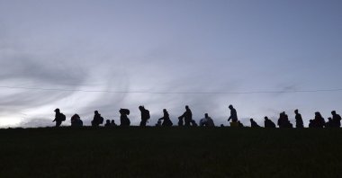German federal police officers guide a group of migrants on their way after crossing the border between Austria and Germany in Wegscheid near Passau, Germany, Oct. 28, 2015. (AP Photo)