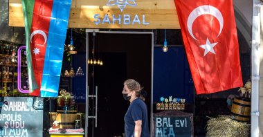 A woman walks past a shop decorated with flags of Azerbaijan and Turkey in Baku, Oct. 14, 2020. (AFP Photo)