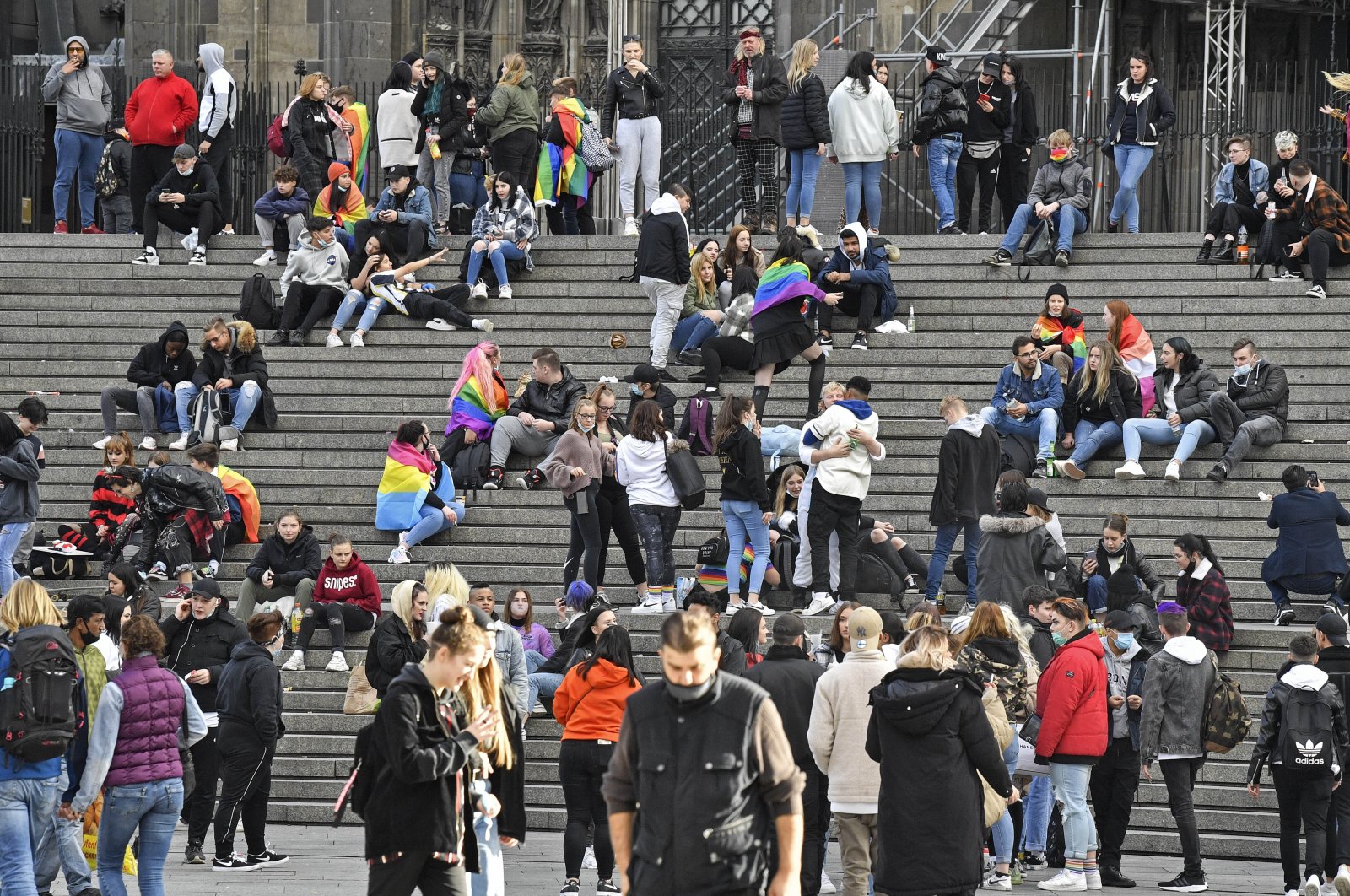 Young people meet without social distancing, despite the coronavirus pandemic, in front of the cathedral in the center of Cologne, Germany, Oct. 11, 2020. (AP Photo)