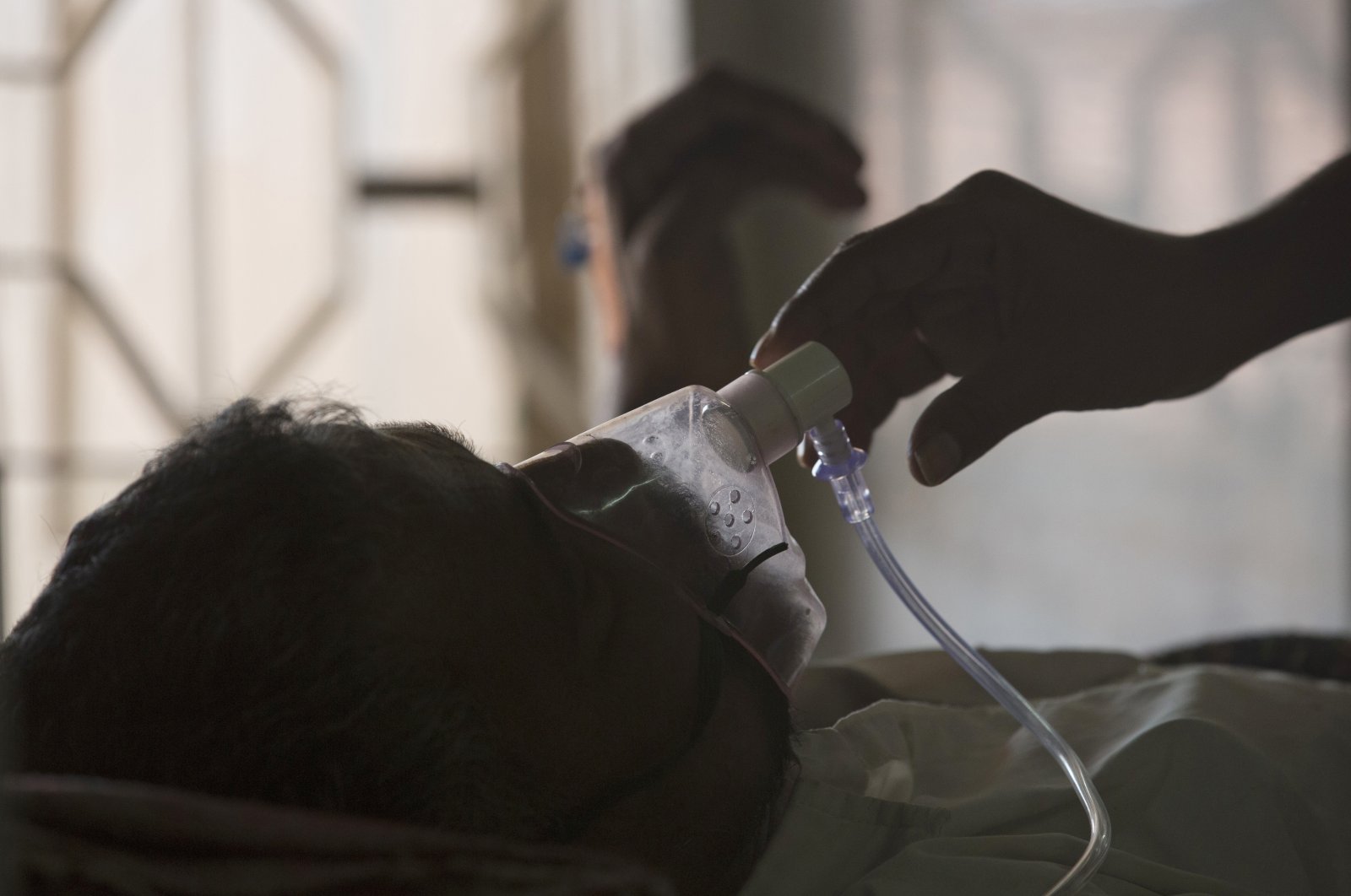 A relative adjusts the oxygen mask of a tuberculosis patient at a hospital in Hyderabad, India, March 24, 2018. (AP Photo)
