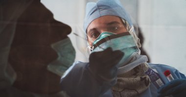 A technician takes a nasal swab for a new coronavirus detection test at a drive-thru testing facility in Abu Dhabi, United Arab Emirates, April 2, 2020. (AP Photo)