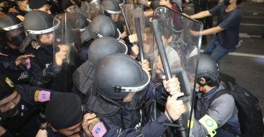 Pro-democracy protesters push Thai policemen with riot shields during a demonstration in Bangkok, Thailand, Thursday, Oct. 15, 2020. (AP Photo)