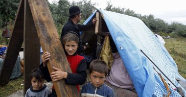 A Roma family stands outside their makeshift shelter built after police seized their caravan two weeks earlier in an illegal camp in Roubaix, near Lille, northern France, Aug. 17, 2010. (Reuters Photo)