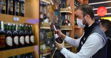 A police officer inspects a liquor store to detect possible bootleg drinks in Mersin, southern Turkey, Oct. 13, 2020. (DHA Photo)