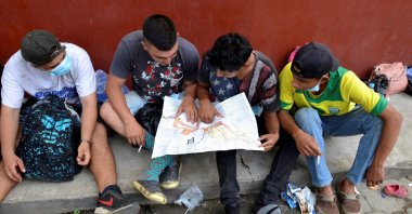 A group of Honduran migrants who are trying to reach the U.S., look at a Central America and Mexico map outside a migrant shelter as they wait to move toward the Guatemala and Mexico border, in Tecun Uman, Guatemala, Oct. 3, 2020. (Reuters Photo)