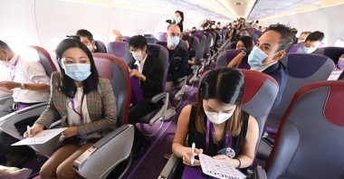 Staff members from budget carrier HK Express take part in a preview "Flycation" flight around Hong Kong on Oct. 15, 2020, during an inaugural "flight to nowhere" journey filled with media and staff, sparking criticism from environmentalists. (AFP Photo)