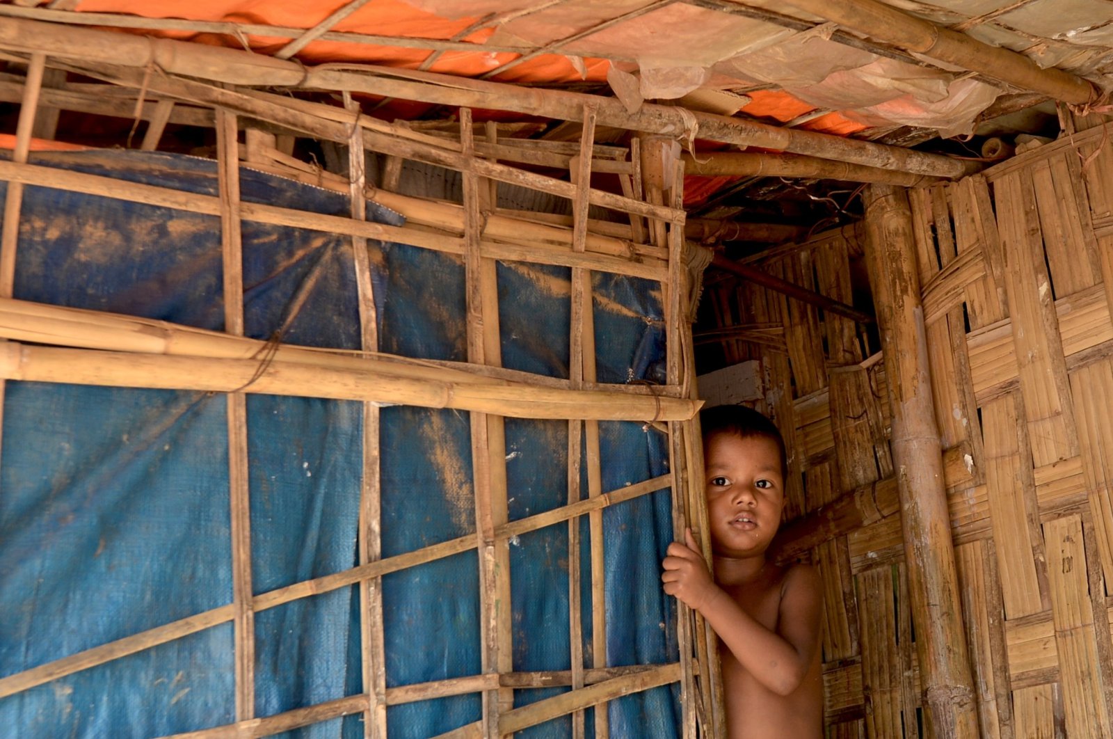 A Rohingya refugee child peeps out from his hut in Kutupalong refugee camp in Ukhia on Oc. 11, 2020. (AFP Photo)