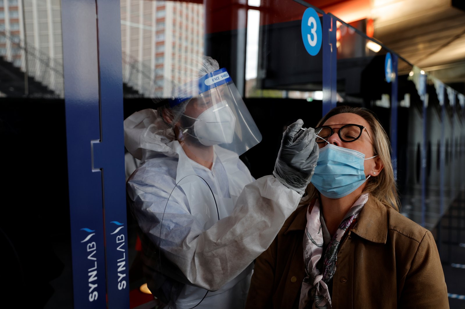A health worker, wearing a protective suit and a face mask, administers a nasal swab to a patient in a temporary testing site for the coronavirus disease (COVID-19) at the Zenith Arena in Lille, France, October 15, 2020.  (Reuters Photo)