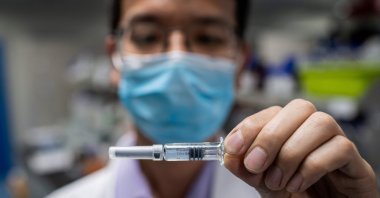 An engineer shows an experimental vaccine against COVID-19 that was tested at the Quality Control Laboratory at the Sinovac Biotech facilities in Beijing, April 29, 2020. (AFP Photo)