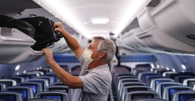 A passenger wears personal protective equipment on a Delta Airlines flight after landing at Minneapolis−Saint Paul International Airport, in Minneapolis, Minnesota, May 28, 2020. (AP Photo)