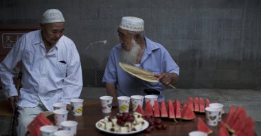 Chinese Muslim men chat as they wait for the time to break their fast during the Muslim holy month of Ramadan at Niujie Mosque, the oldest and largest mosque in Beijing, China, July 2, 2014. (AP Photo)