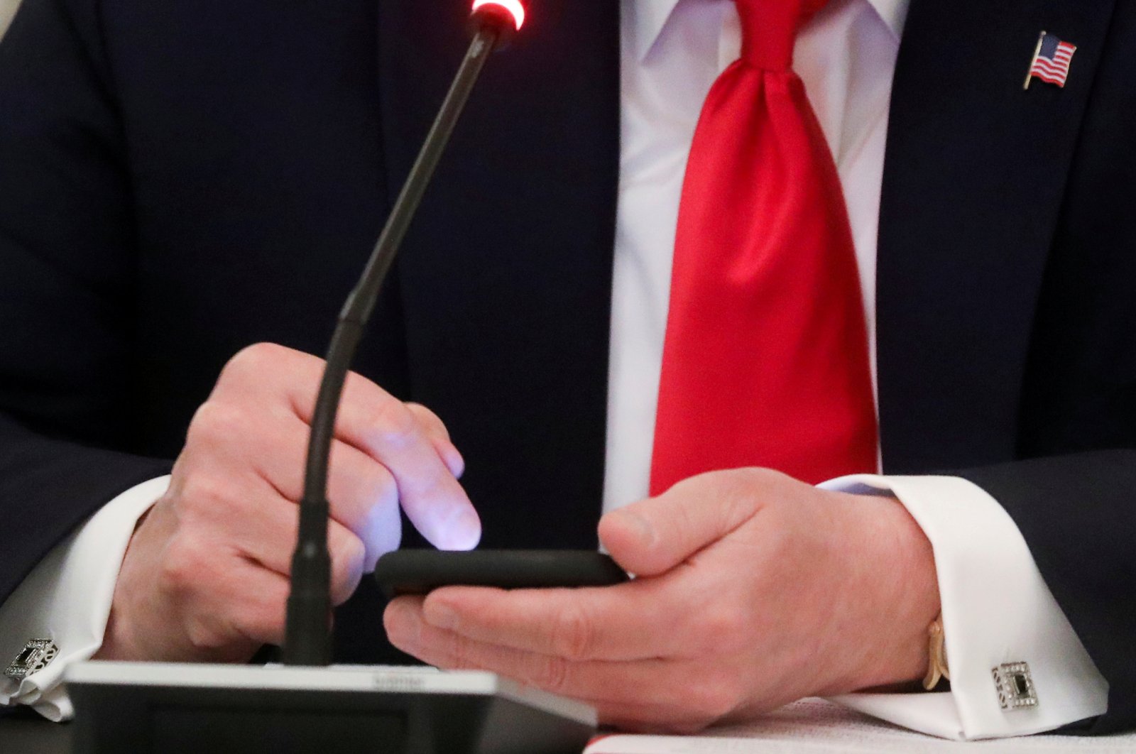 U.S. President Donald Trump taps the screen on a mobile phone at the approximate time a tweet was released from his Twitter account, during a roundtable discussion on the reopening of small businesses in the State Dining Room at the White House in Washington, D.C., U.S., June 18, 2020. (Reuters Photo)