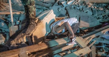 A man searches for relatives in the rubble as rescue teams work at a site hit by an Armenian rocket amid Azerbaijani military operation to liberate Armenian-occupied Nagorno-Karabakh region, in Ganja, Azerbaijan, Oct. 17, 2020. (AFP Photo)
