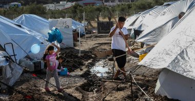 A girl holds an air balloon as she walks among tents in the Kara Tepe camp for refugees and migrants on the Greek island of Lesbos, Oct. 14, 2020. (AFP Photo)