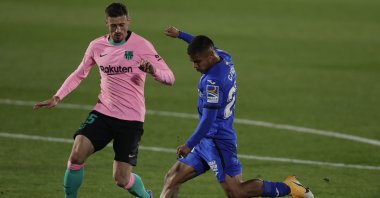 Getafe's Cucho Hernandez (R) takes a shot with Barcelona's Sergio Busquets trying to interrupt during a La Liga match in Getafe, Spain, Oct. 17, 2020. (AP Photo)