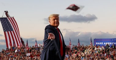U.S. President Donald Trump tosses face masks to the crowd as he takes the stage for a campaign rally, in Sanford, Florida, U.S., Oct. 12, 2020. (Reuters Photo)