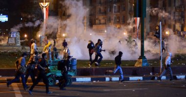 Egyptian anti-military demonstrators run for cover from tear gas fired by riot police during clashes in Tahrir Square in Cairo on Nov. 19, 2013. (AFP Photo)
