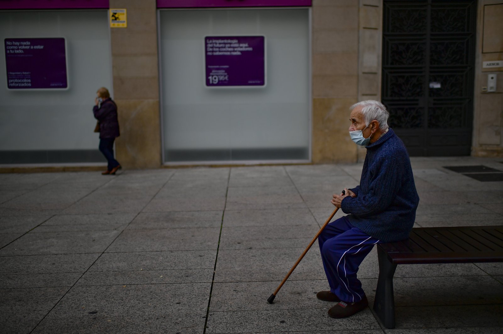 An elderly man sits on a bench wearing a face mask, Pamplona, northern Spain, Oct. 17, 2020. (AP Photo)