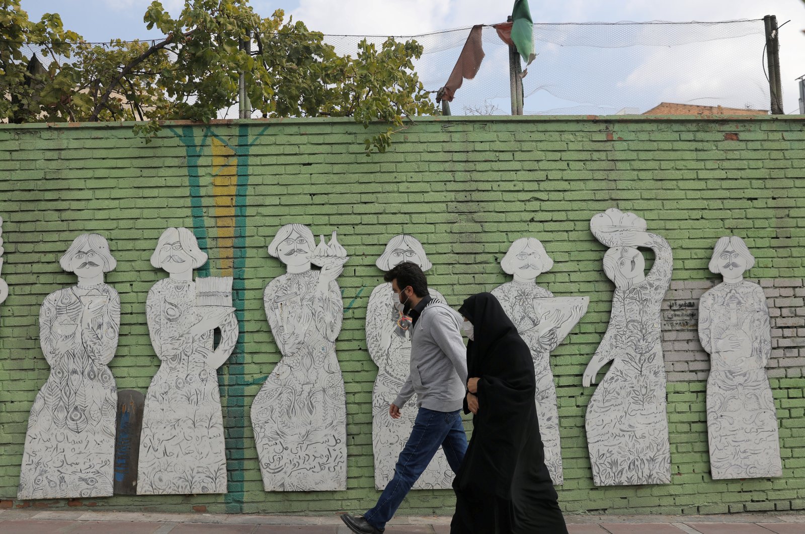 Iranians wearing face masks walk on a street after government authorities made it mandatory for all to wear face masks in public following the outbreak of the coronavirus disease (COVID19), in Tehran, Iran, Oct. 10, 2020. (Photo by West Asia News Agency via Reuters )