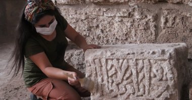 An archaeologist works on an inscription featuring Arabic writing on a basalt stone, Şanlıurfa, southeastern Turkey, Oct. 19, 2020. ( AA PHOTO)