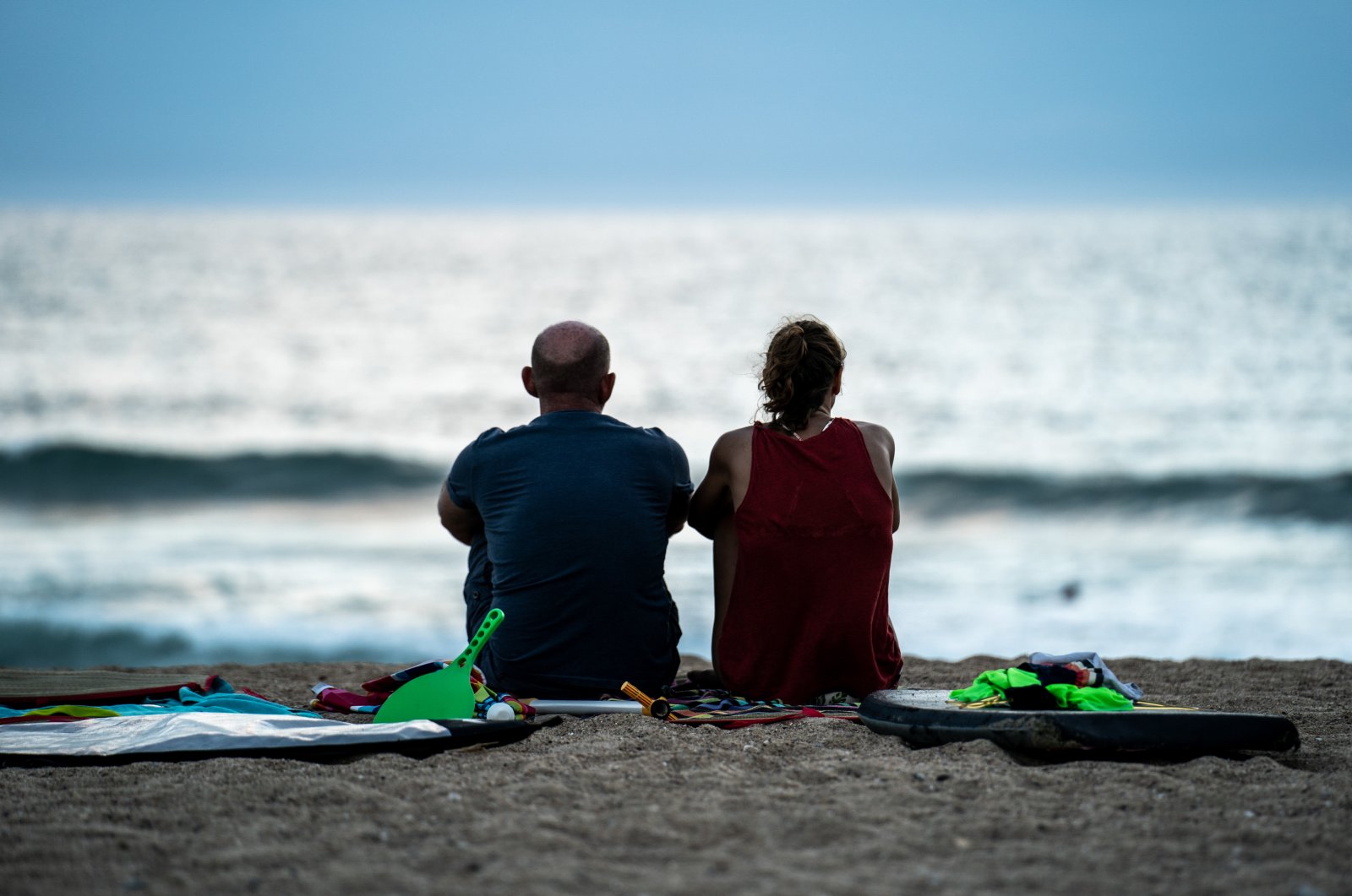 A man and a woman look at the sea surrounded by their children's beach stuff at the Savane beach, Capbreton, France, Aug. 20, 2020. (Reuters Photo)