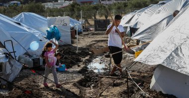 A girl holds a balloon as she walks among tents in the Kara Tepe camp for refugees and migrants on the island of Lesbos, Greece, Oct. 14, 2020. (AFP Photo)