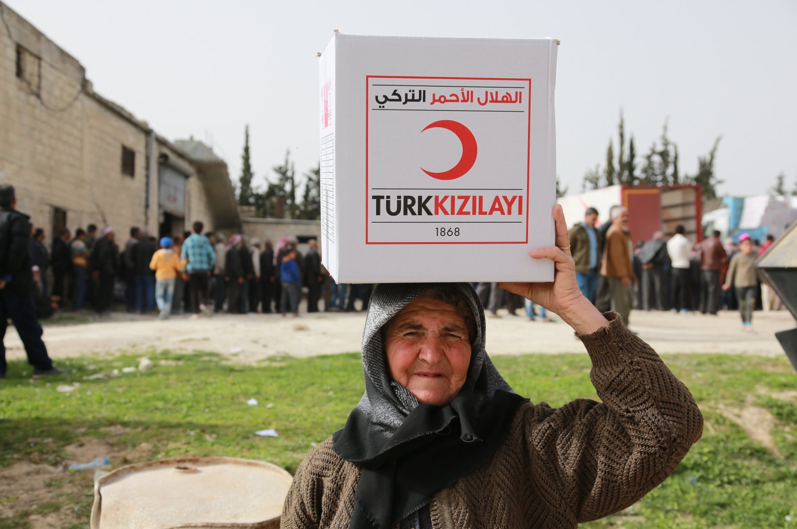 A Syrian elderly woman smiles after receiving an aid box donated by the Turkish Red Crescent in Afrin province on March 31, 2018 (AA File Photo)