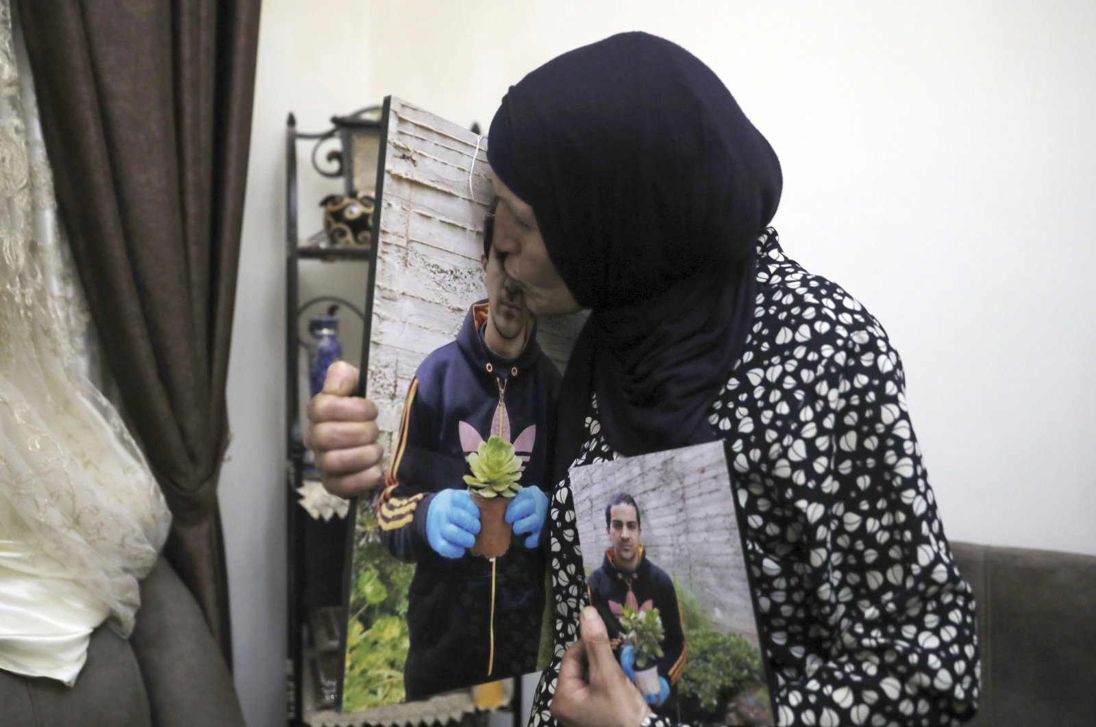 Rana kisses a photo of her son, Eyad Hallaq, in their home in Wadi Joz, a Palestinian neighborhood in east Jerusalem, June 3, 2020. (AP Photo)