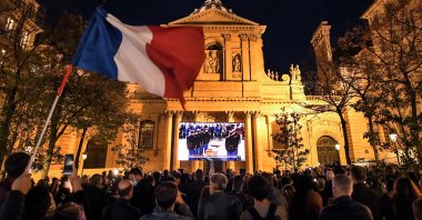An attendee waves a French flag during a demonstration against the killing of a French teacher by an extremist attacker, Oct. 21, 2020. (AFP Photo)