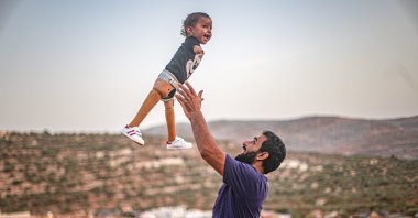 Father Khaled bounces his son Muhammad, in Idlib, Syria, Oct. 22, 2020. (AA Photo) 