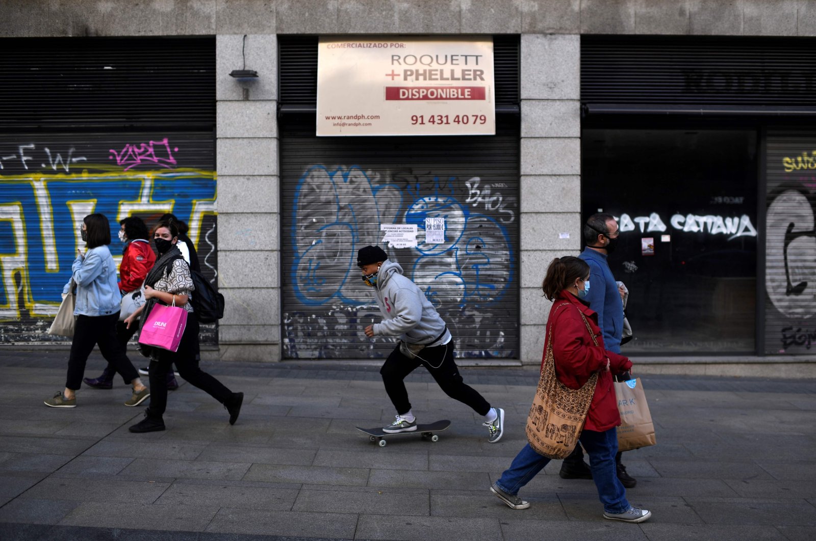 People walk past a closed shop on Gran Via, the main avenue of central Madrid, Oct. 16, 2020. (AFP Photo)